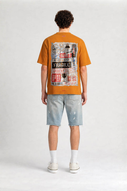 Person wearing an orange t-shirt with a graphic design on the back, standing against a white background