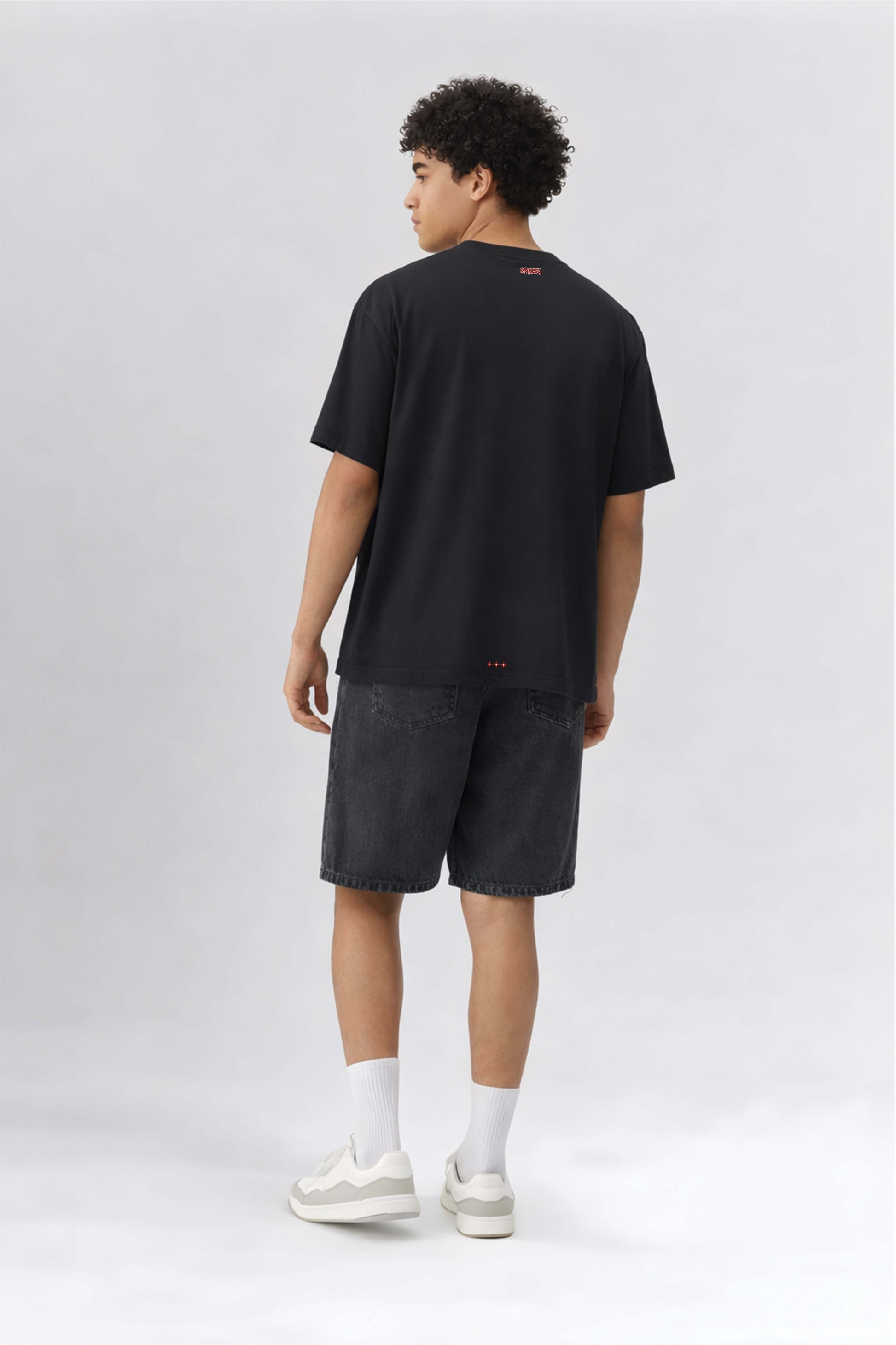 Person wearing a black t-shirt and shorts on a white background