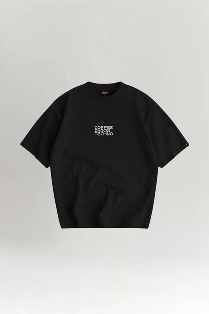 Black t-shirt with 'COFFEE CHAOS TECHNO' text on a light gray background