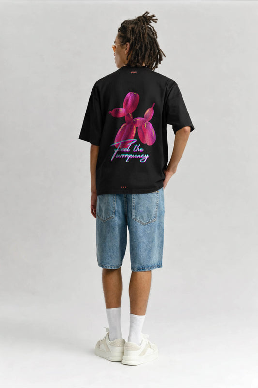 Person wearing a black t-shirt with a pink flower design and text on the back, standing against a plain background.