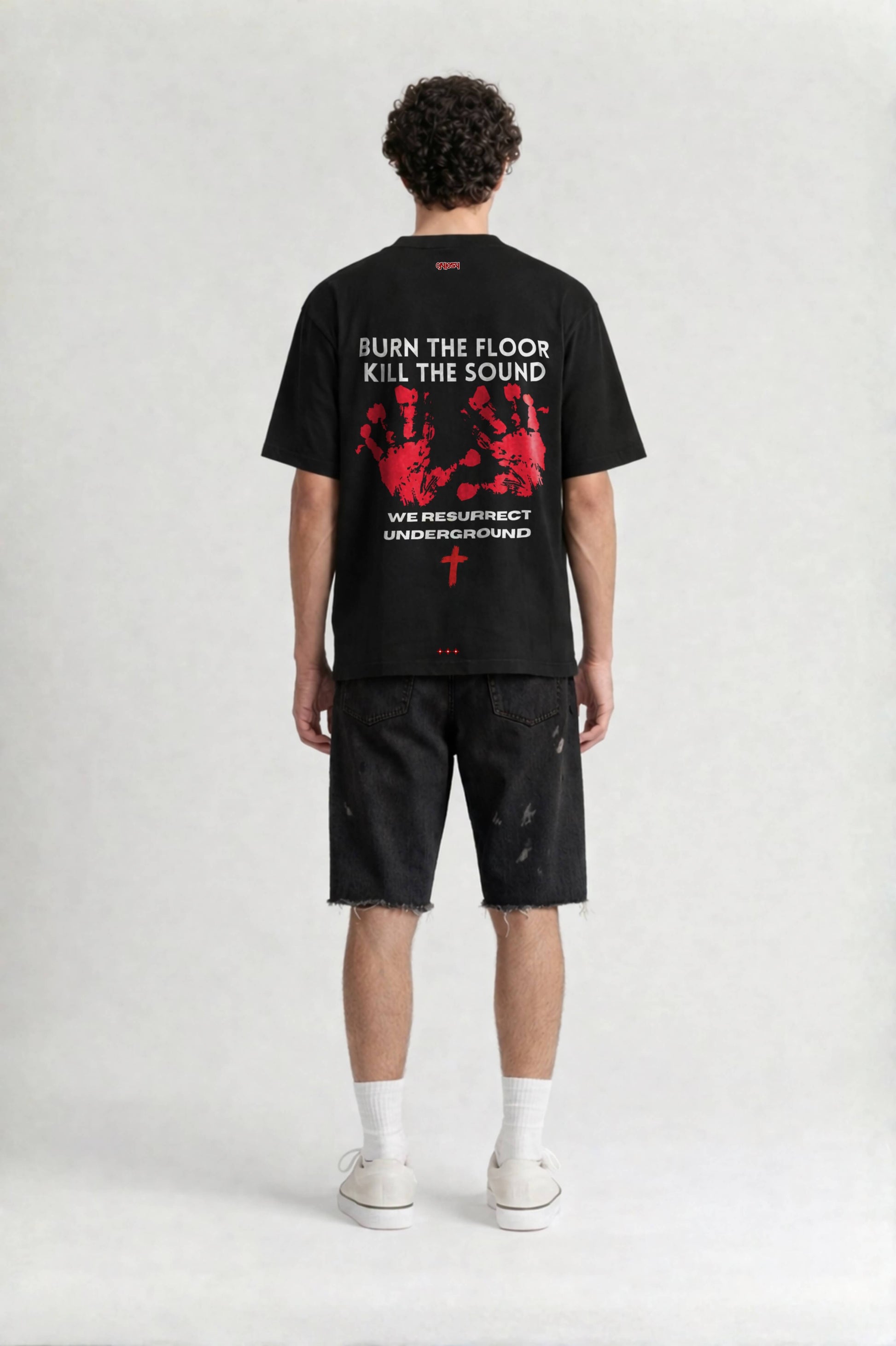 Person wearing a black t-shirt with graphic design and text on the back, standing against a white background.