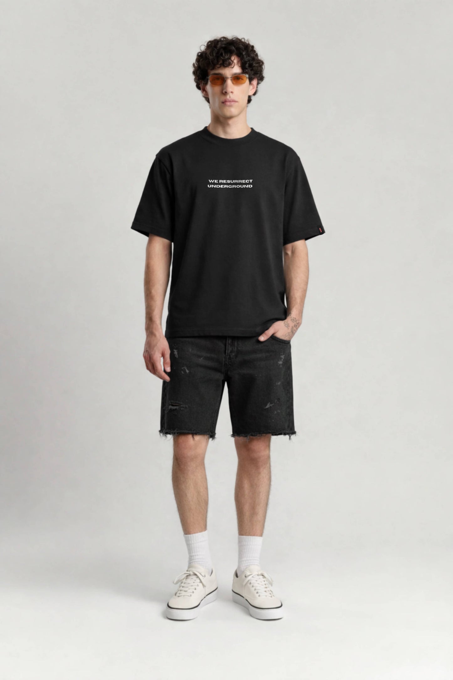 Person wearing a black t-shirt and shorts on a white background