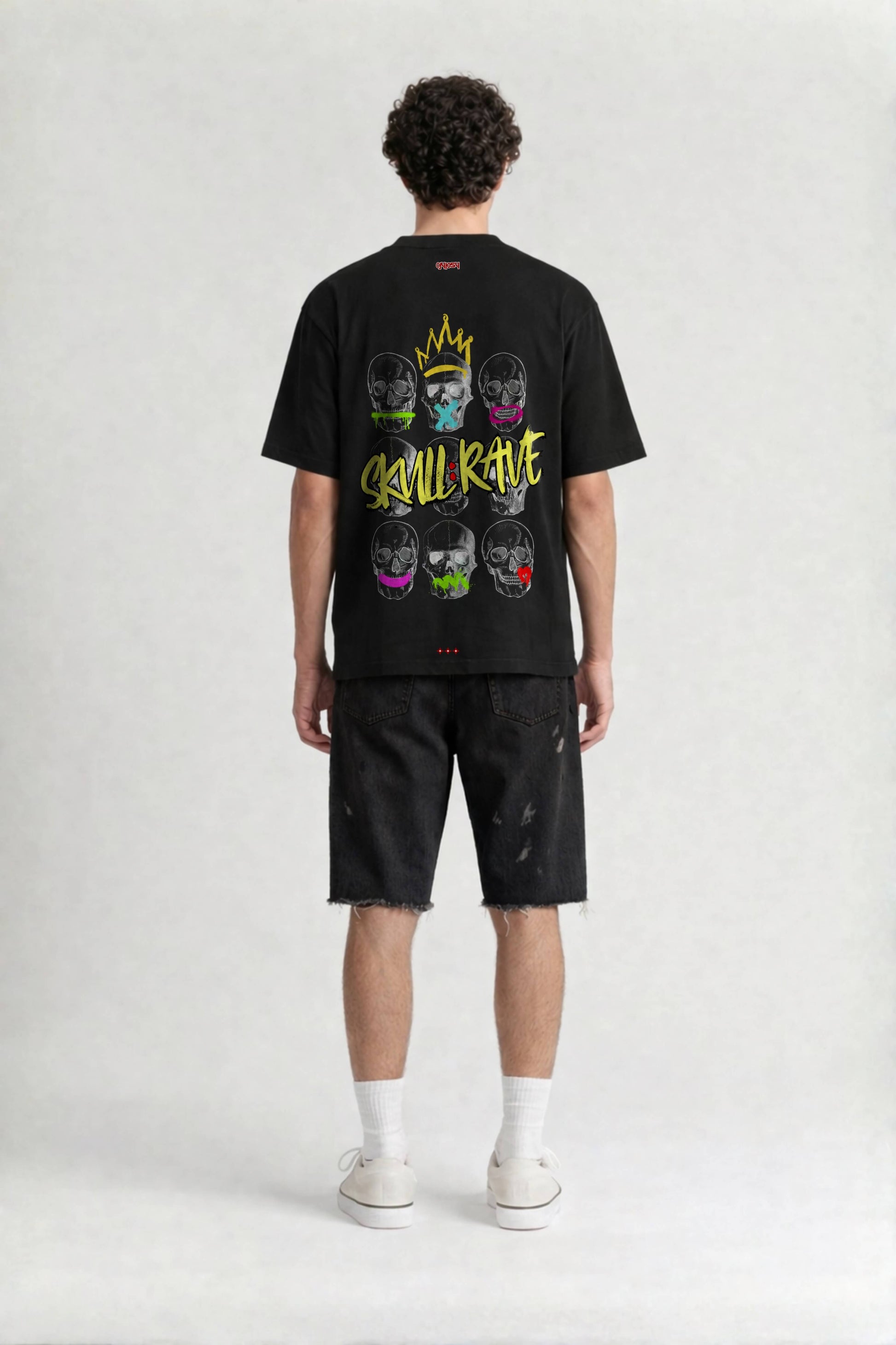 Person wearing a black t-shirt with colorful graphic design on the back, standing against a white background