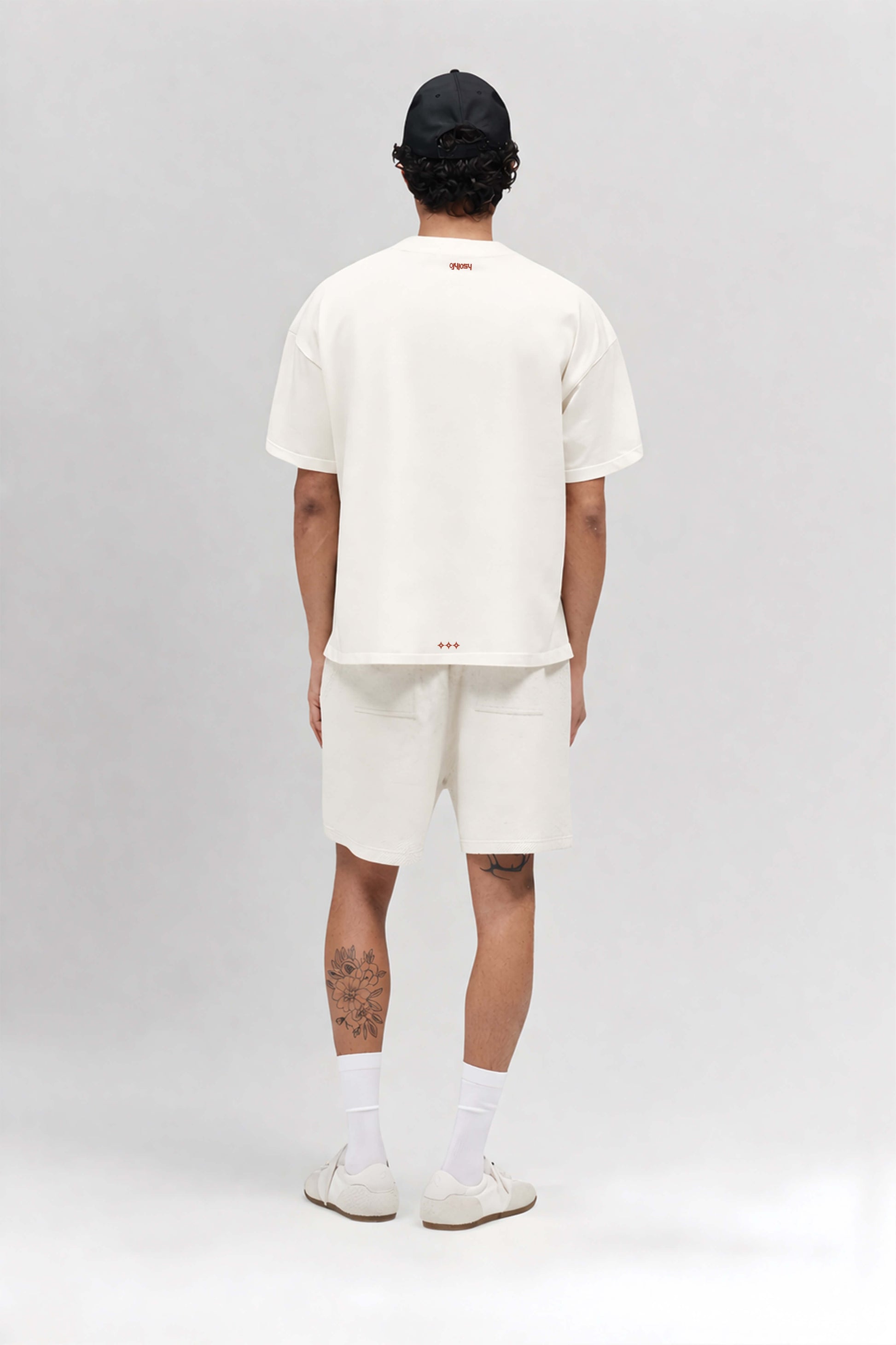 Person wearing a white t-shirt and shorts set on a plain background