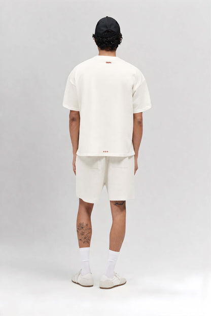 Person wearing a white t-shirt and shorts set on a plain background