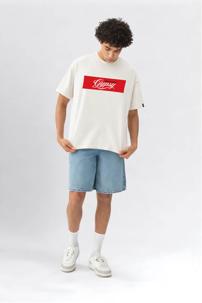 Person wearing a white t-shirt with a red logo and light blue shorts on a white background