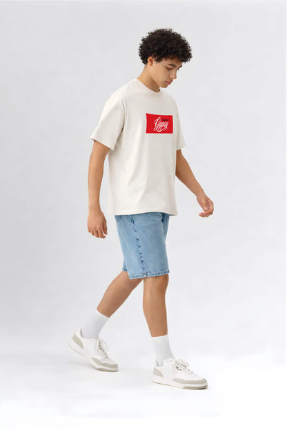Person wearing a white t-shirt with a red logo and blue shorts on a light gray background