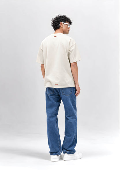 Person wearing an off white t-shirt and blue jeans on a white background