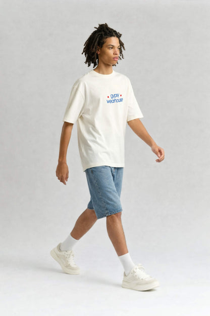 Person wearing a white t-shirt with text and blue shorts on a light gray background