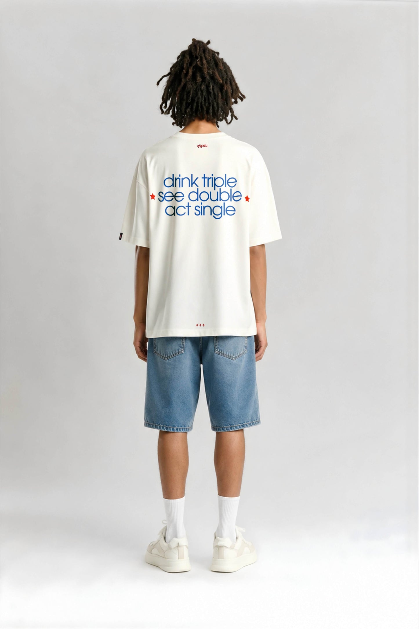 Person wearing a white t-shirt with text on the back, standing against a plain background