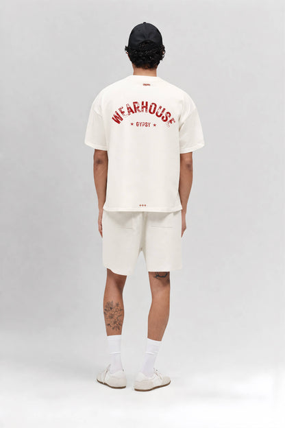 Person wearing an off white t-shirt with text and shorts on a gray background