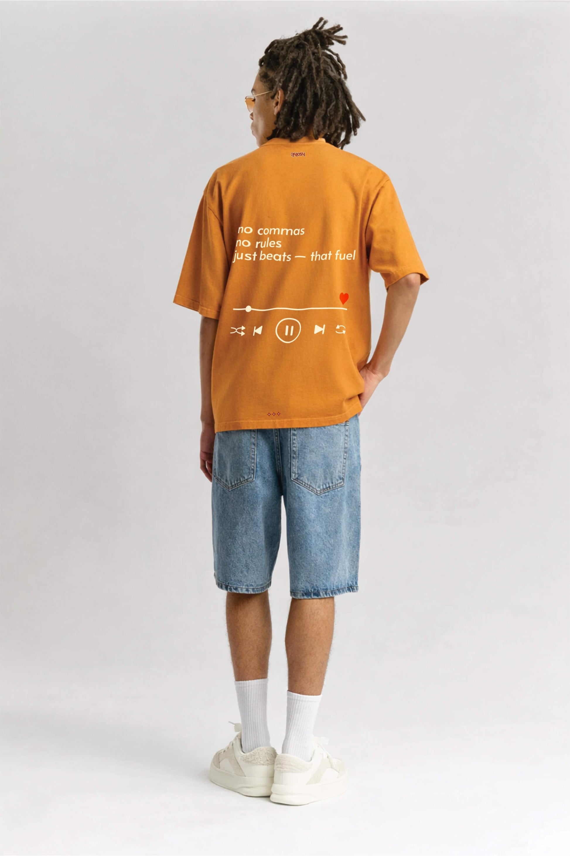 Person wearing an orange t-shirt with text and graphics on a white background