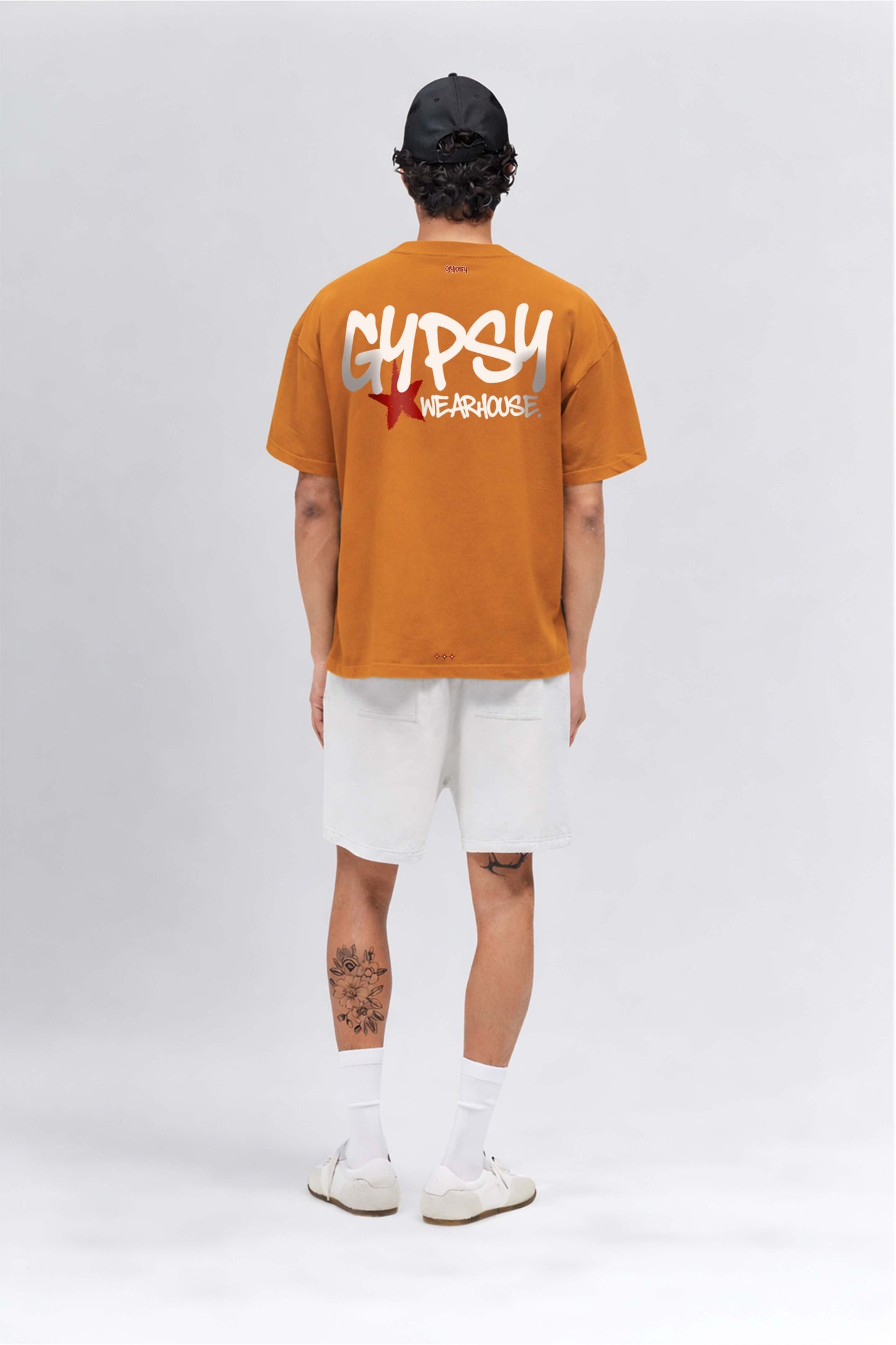 Person wearing an orange t-shirt with 'Gypsy Wanderer' text on a white background